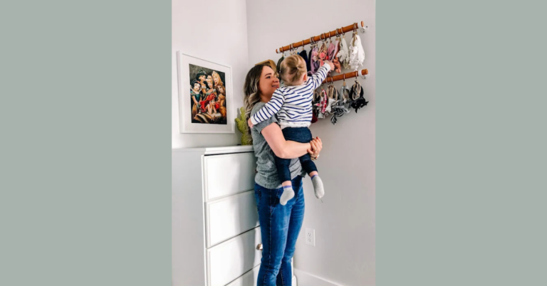 Woman holding a baby looking at the DIY bow storage