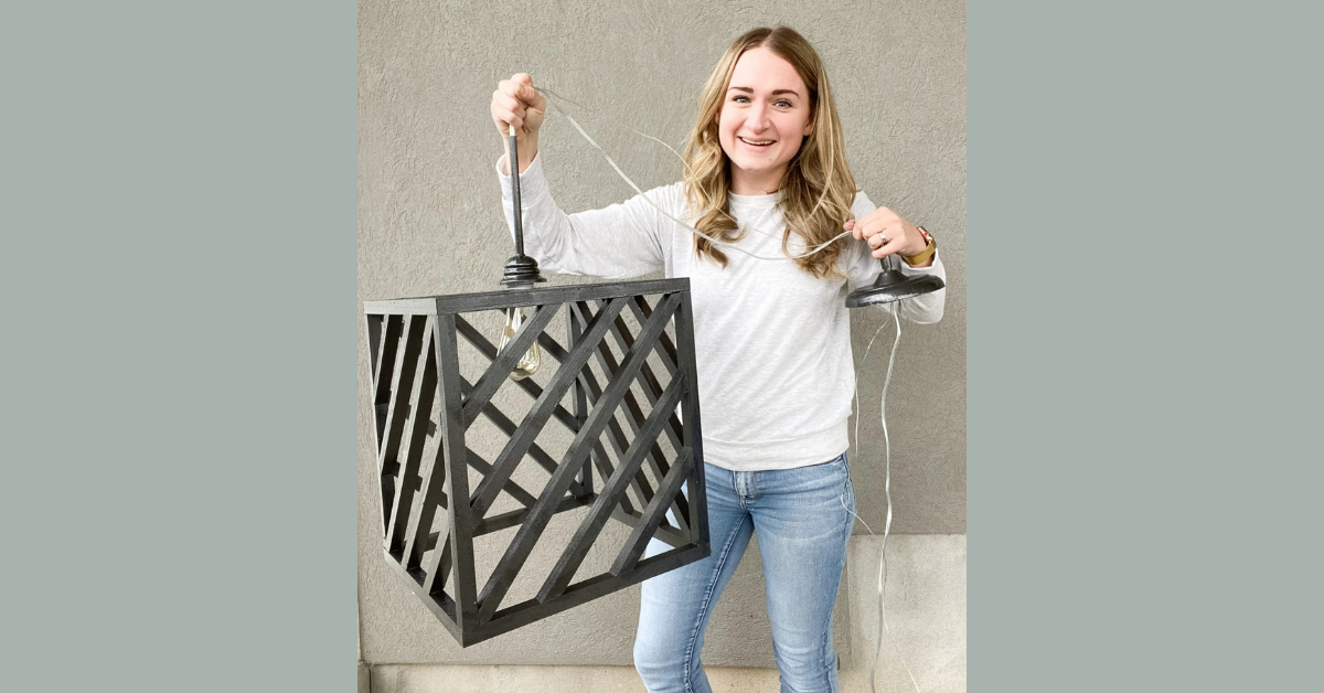 Woman holding a black modern farmhouse custom light fixture