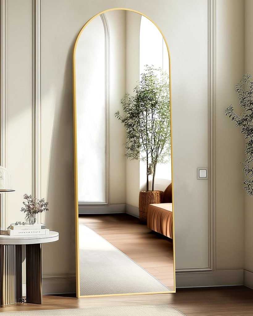 Gold arched mirror leaning on the wall