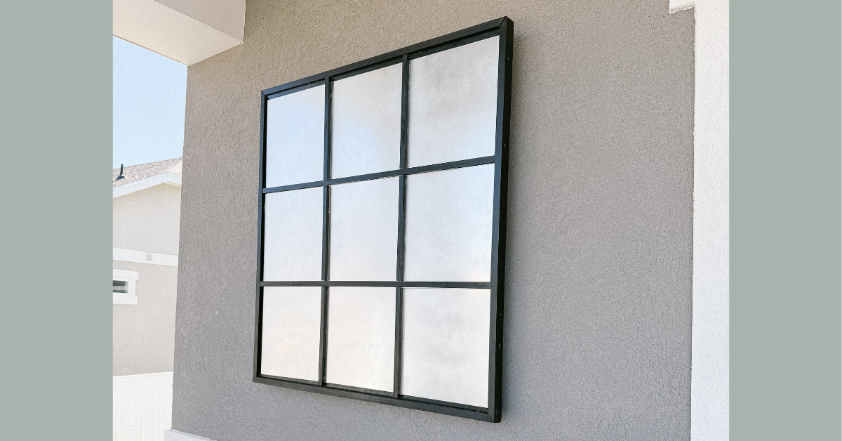 A faux window created with frosted glass spray paint and black wood trim.
