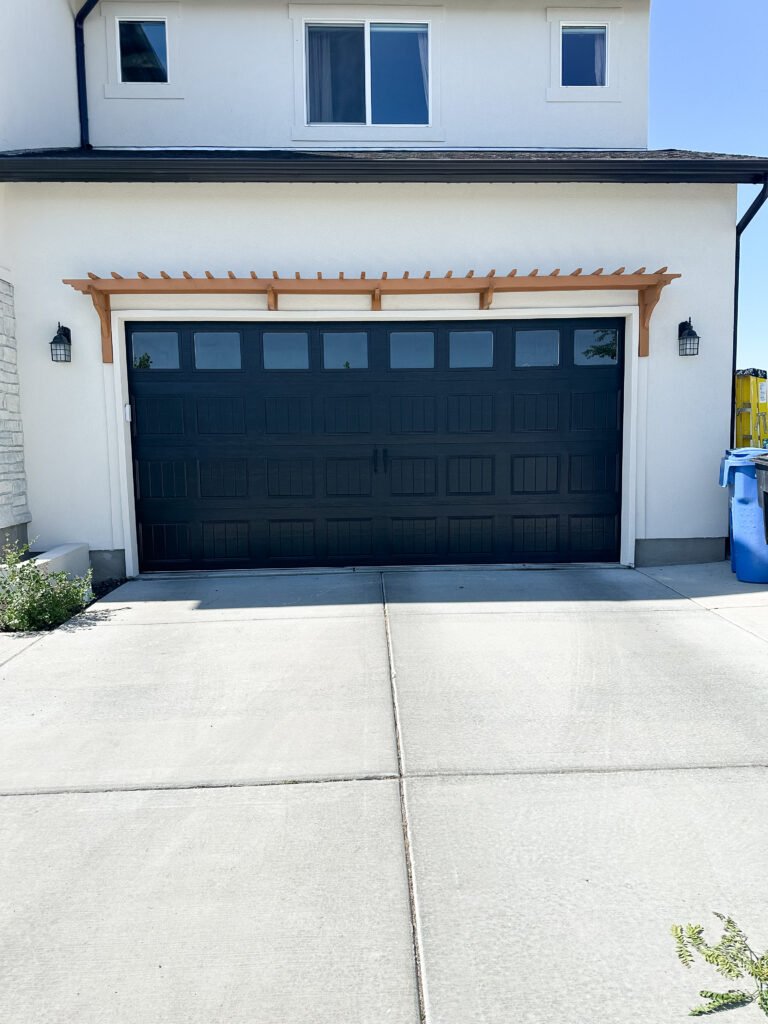 The after of our DIY garage pergola! The wood looks great against the white stucco.