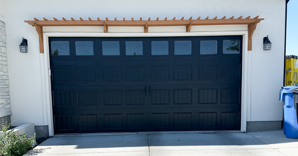 Wood garage pergola over a black garage door