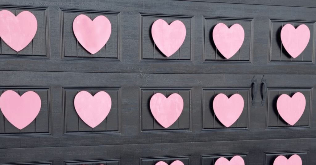 Outdoor Valentine's Decor: Pink wooden hearts on a black garage door