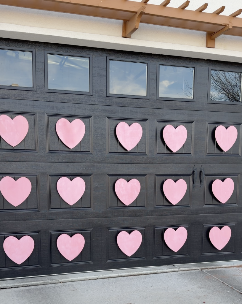 Outdoor Valentine's Decor: Pink wooden hearts on a black garage door