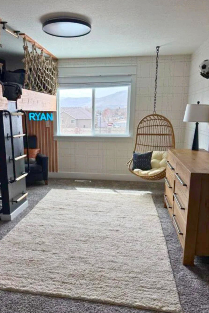 Large beige area rug, hanging chair in the corner, light wood dresser