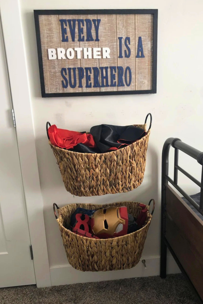 Cool Kids' Room Ideas: Superhero costume storage with woven baskets on wall; sign above reads "every brother is a superhero"