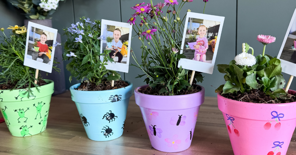 DIY Mother's Day Crafts idea: brightly painted flower pots with fingerprint art. Kid's photos attached to a craft stick in the plant's soil