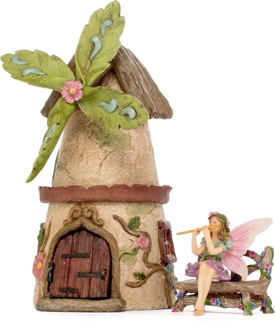 Fairy garden windmill house with fairy sitting on a bench next to it
