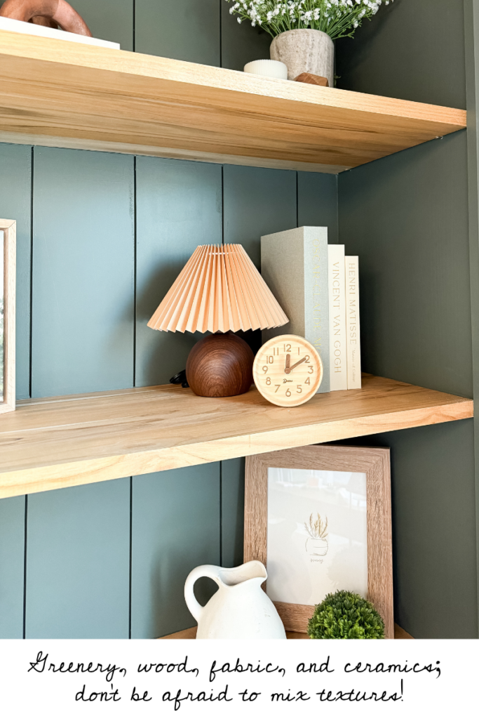 Shelf styling example: Use different textures, including greenery, wood, ceramics, and fabric-covered books