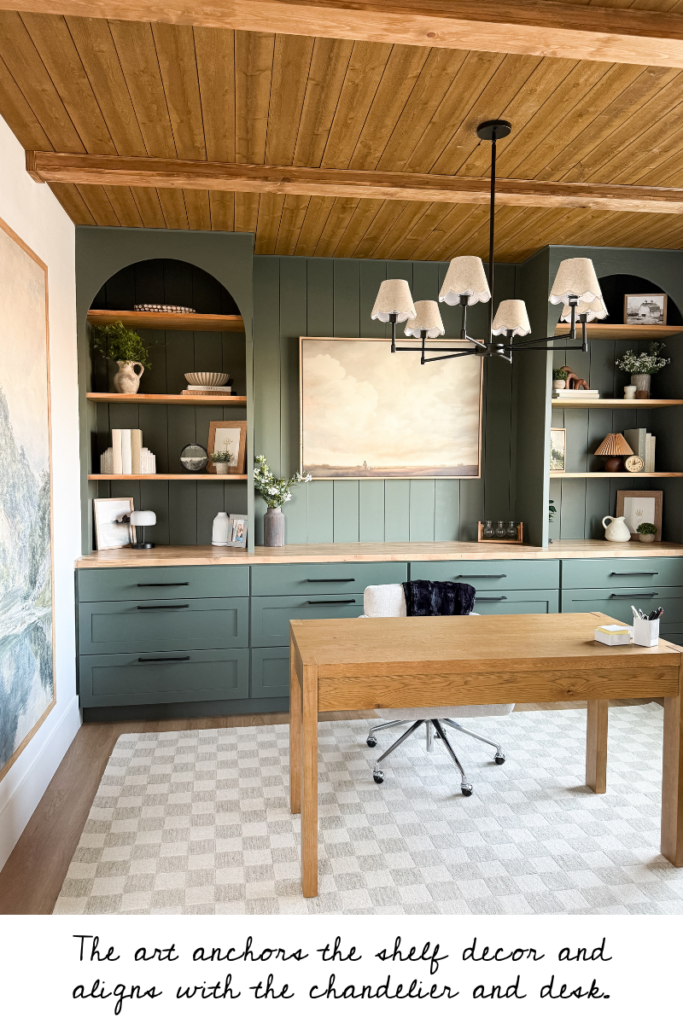 Home office with dark green built in cabinets, a light wood modern desk, and checkered rug