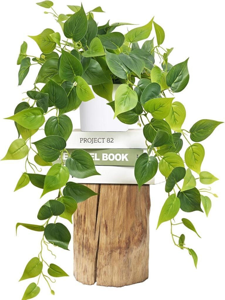 Faux trailing pothos plant on a wood stump and stack of books