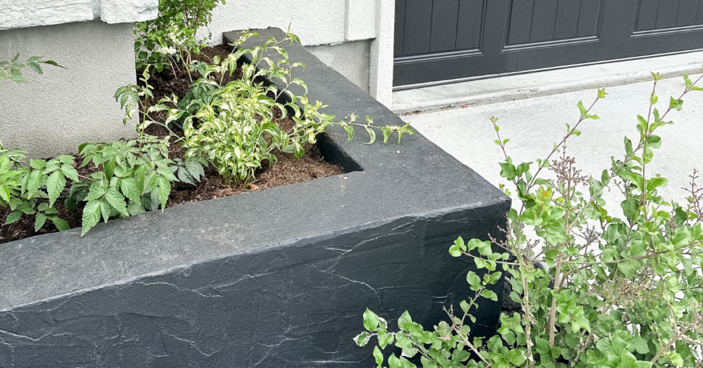 Black cinder block planters with greenery inside