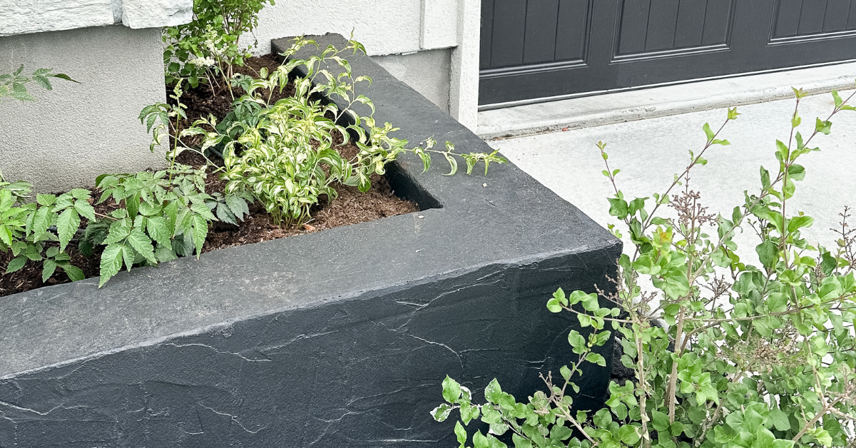 Black cinder block planters with greenery inside