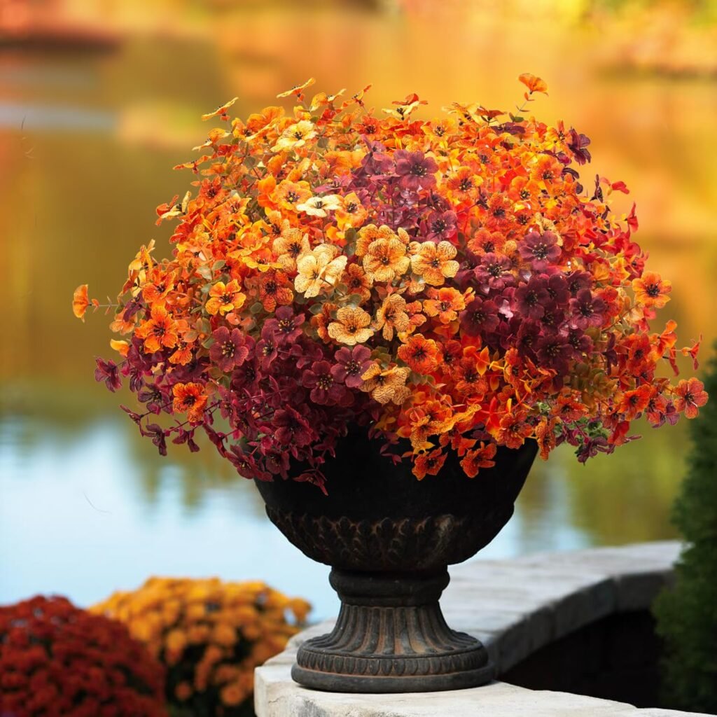 Faux daisies in shades of orange and red in a brown planter