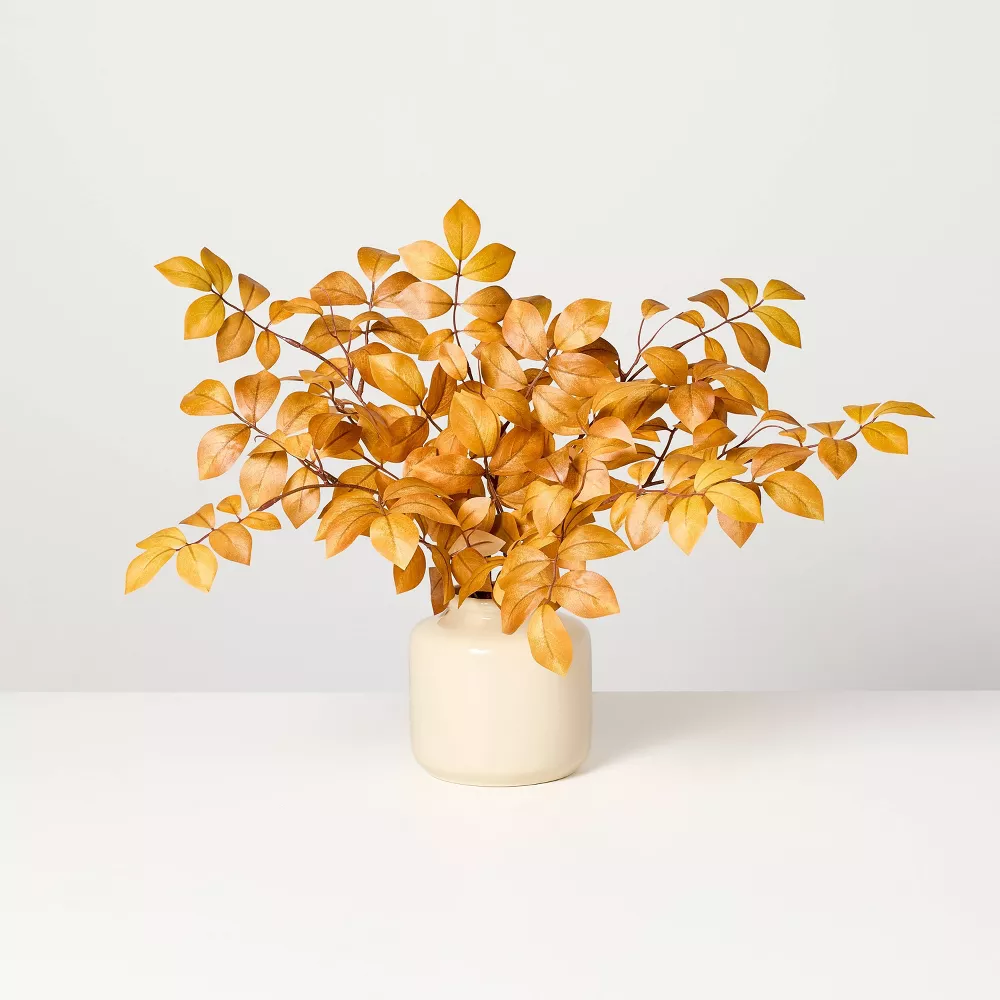 How to style a mantel for every season: stems with orange leaves in cream vase