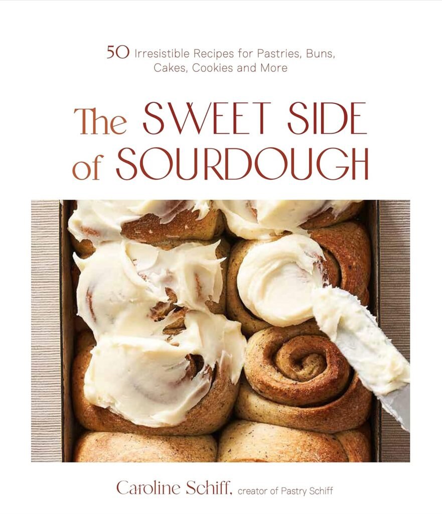 Sourdough tips for beginners: get a cookbook with fun recipes! This one is called The Sweet Side of Sourdough. The cover features a tray of cinnamon rolls, some with icing.