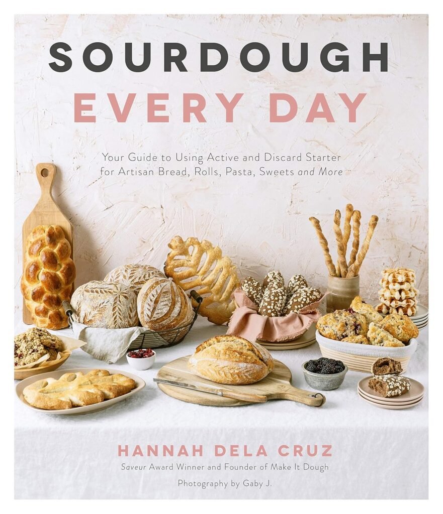 Sourdough tips for beginners: get a cookbook with fun recipes! This one is Sourdough Everyday. The cover features a variety of sourdough breads on a table