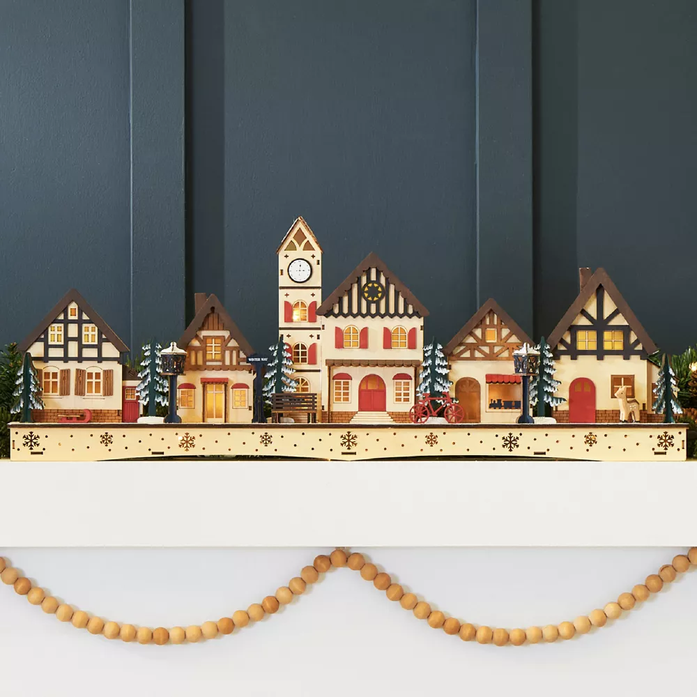 DIY gingerbread village displayed on a Christmas mantel