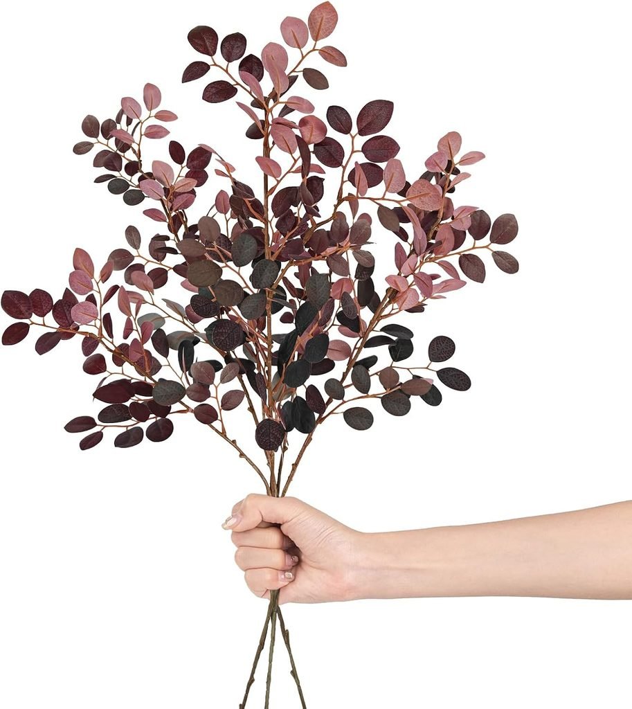 Hand holding a bunch of burgundy eucalyptus stems