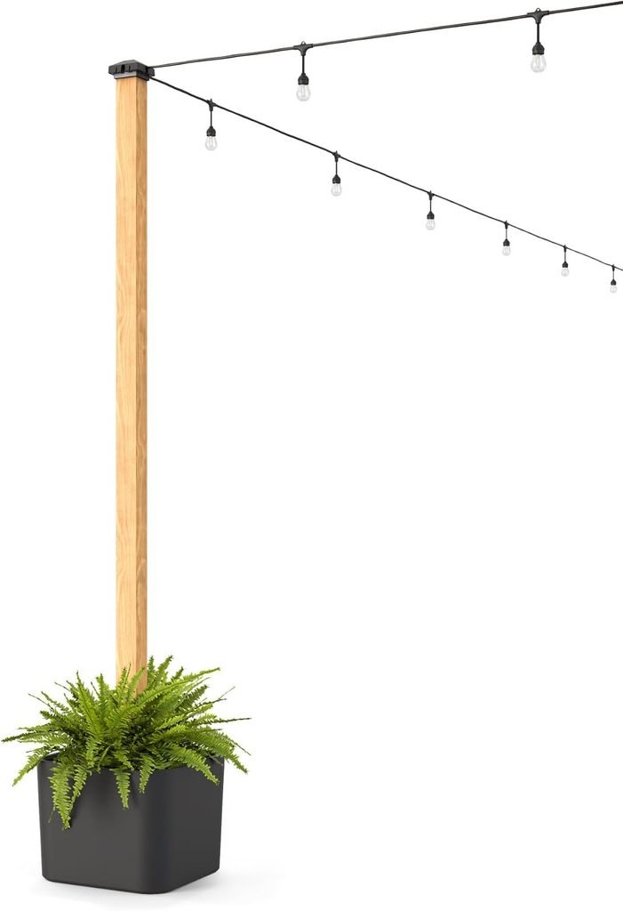 String lights hanging from a wood pole in a black planter as part of the patio transformation
