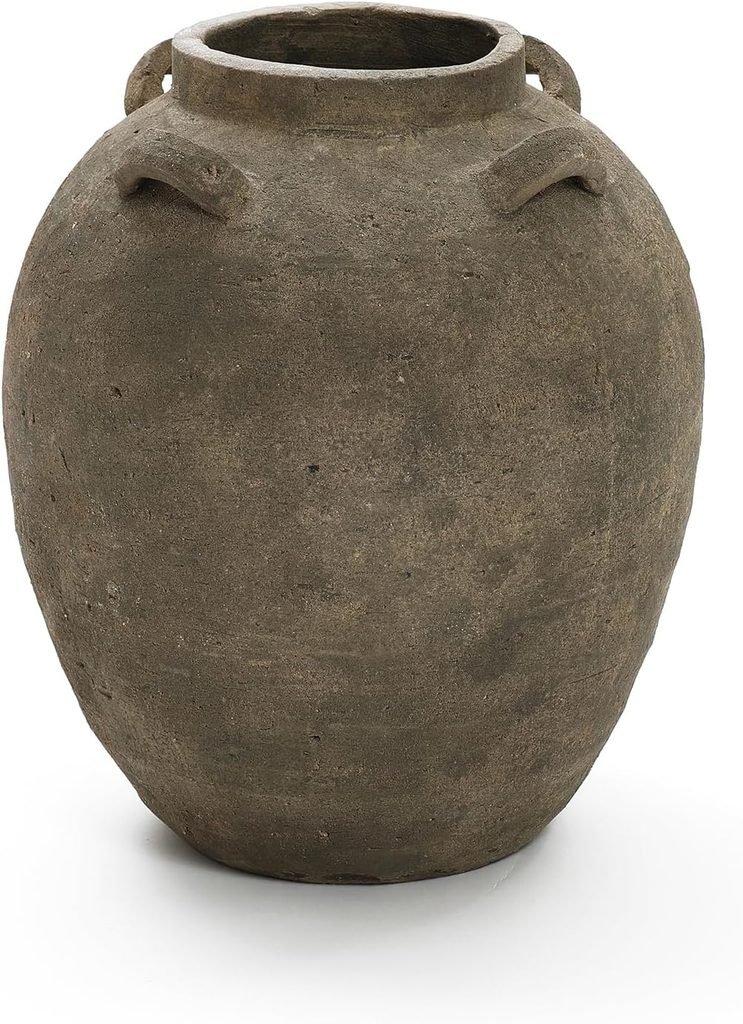 A gray terracotta vase with decorative handles at the top to hold a faux fall floral arrangement