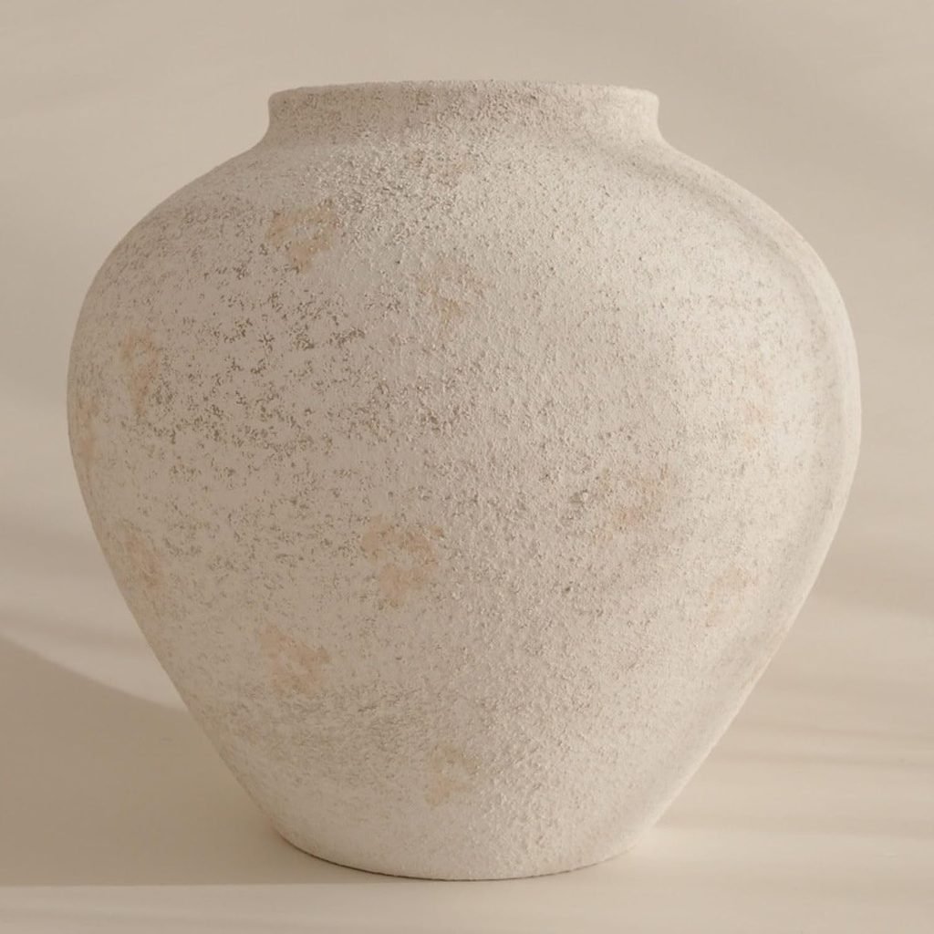 A cream ceramic vase to hold a faux fall floral arrangement