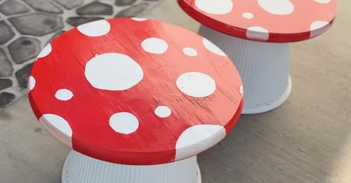 DIY toadstool tables with large white spots against a red background on top, and ribbed white planters acting as the base