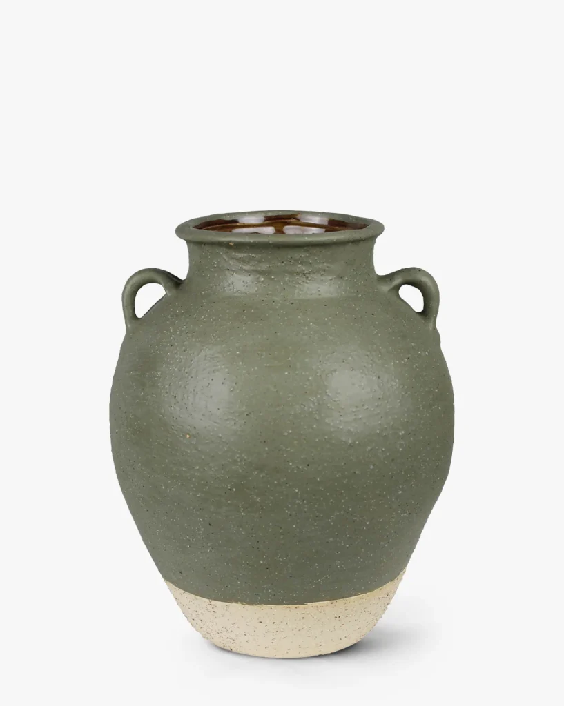 A green and beige handled vase to hold a faux fall floral arrangement